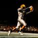 Minneapolis Roosevelt football player catches the ball for a touchdown during a night game