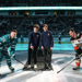 Youth Olympic Games athletes stand poised to drop the puck at a San Joes Sharks Game. San Jose Sharks and Anaheim Ducks captains are ready to take the face-off. 