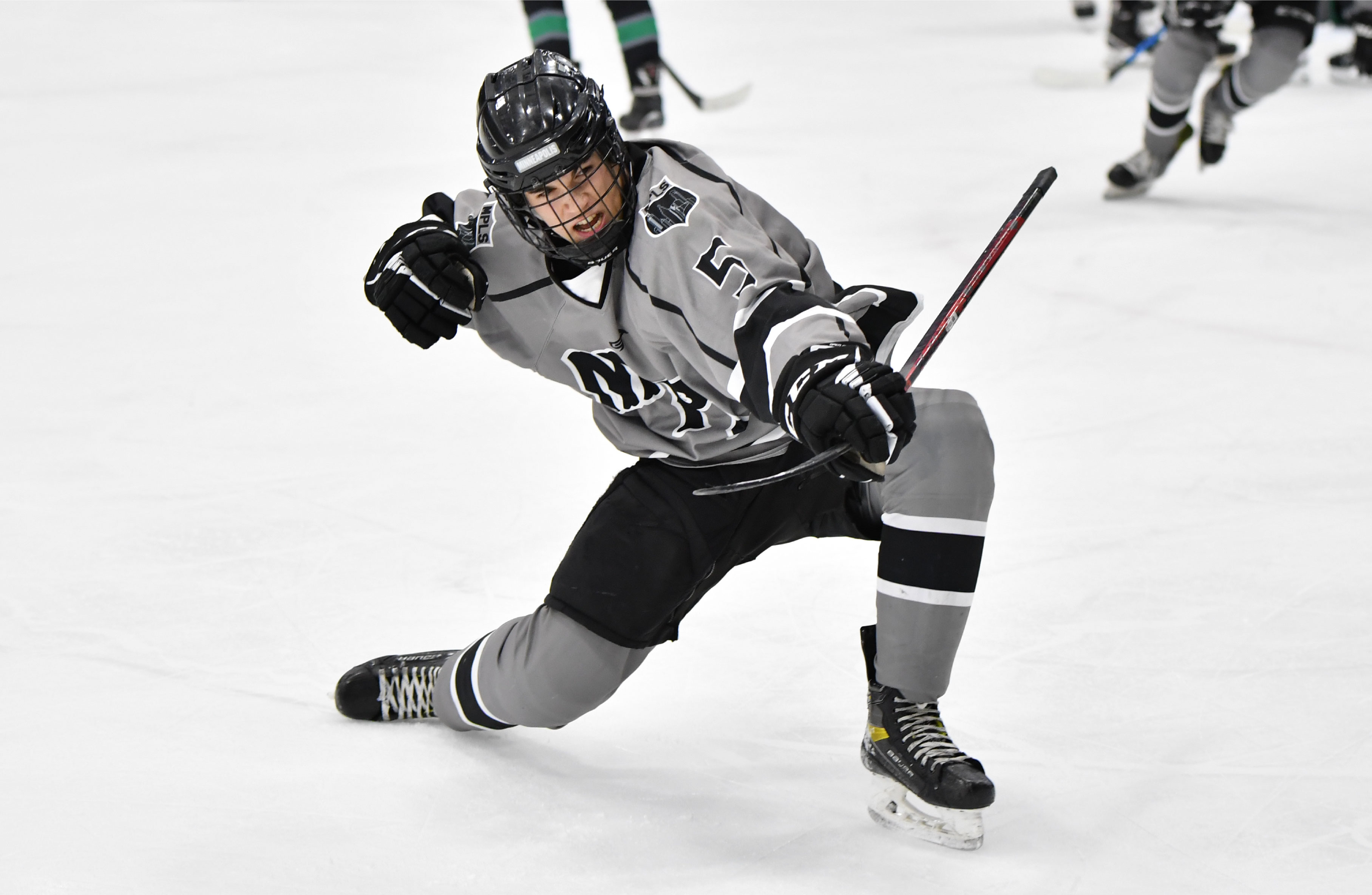 Image of Minneapolis Boys High School Hockey player celebrating on the ice after he scored a goal.