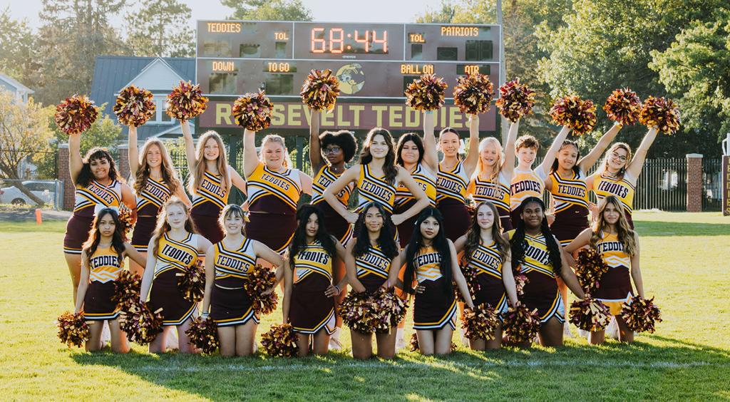 Image of Roosevelt High School Cheer Squad football cheerleaders grouped together for a team photo in front of the scoreboard on the football field in Al Gowans Stadium