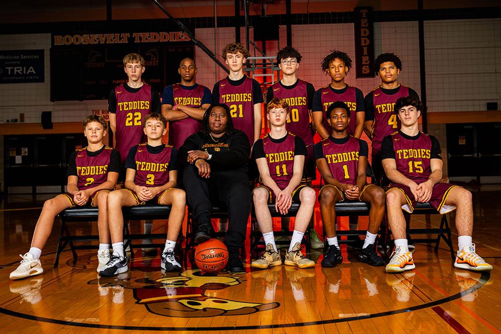 Minneapolis Roosevelt Boys B-Squad team pose in a darkly lit Jack Wells Gymnasium