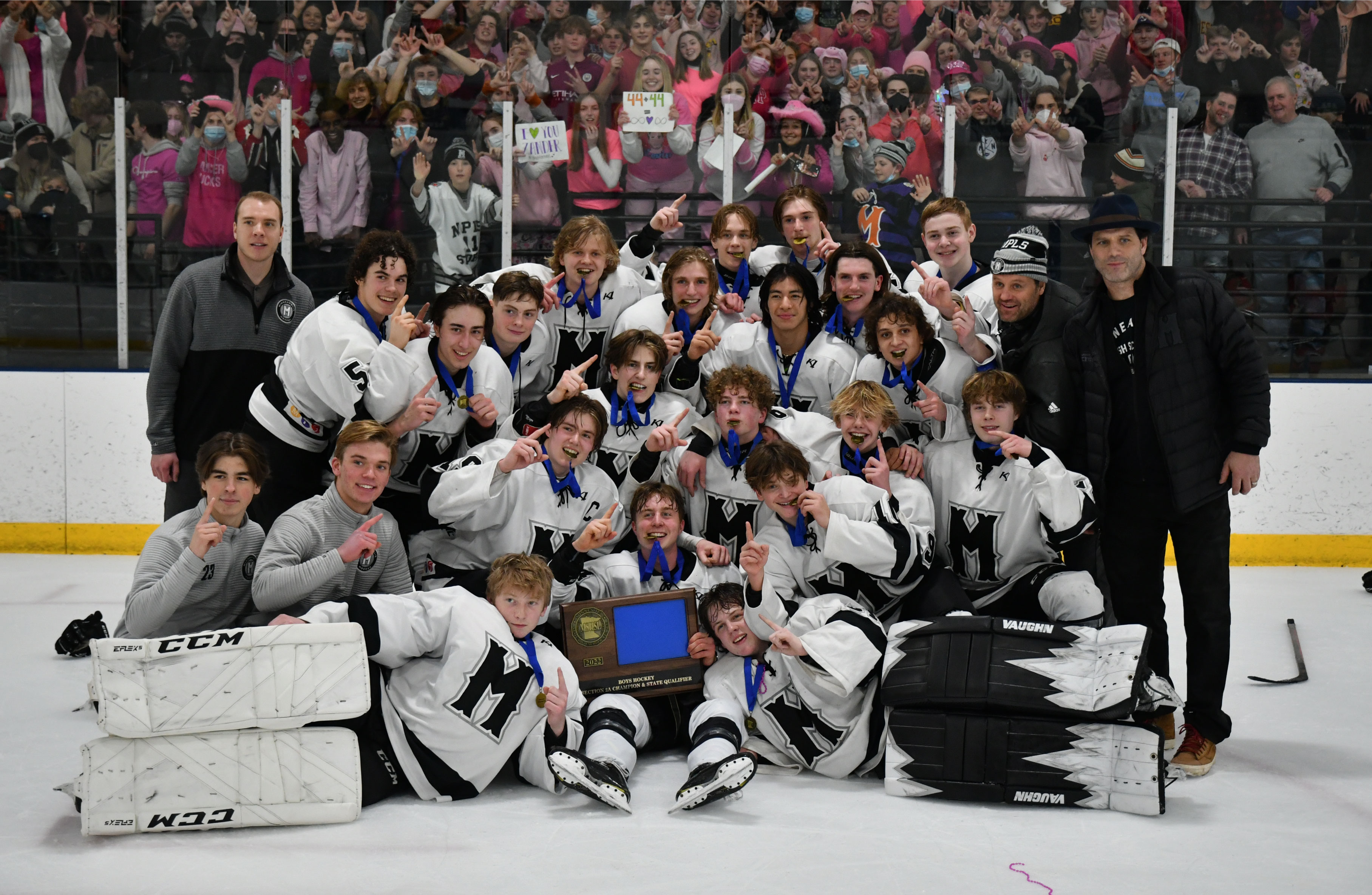 Image of Minneapolis Boys High School Hockey players holding the Section Champions trophy after winning the title
